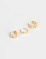 Set de tres earcuffs dorados de metal con diferentes diseños.