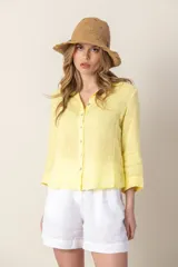 Camisa amarilla de lino con cuello clásico, mangas 3/4 y cierre frontal con botones.
