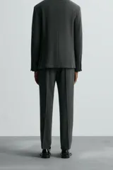 Pantalón de vestir gris oscuro, corte slim fit, confeccionado en tejido con 17% de lana. Cuenta con bolsillos frontales y traseros de vivo con botón. Cierre frontal con cremallera y botón.