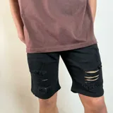 Bermuda de jean negra con corte skinny y roturas en las piernas.