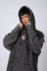 Buzo canguro color ocre con capucha y cordones negros, de corte oversize y confeccionado en tela de algodón friza con teñido artesanal y estampa circular en el pecho.