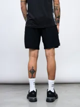 Short deportivo negro de entrenamiento, marca Umbro, con logo estampado en la pierna izquierda y detalles laterales con repetición del logo. Confeccionado en tejido elástico de cuatro direcciones.