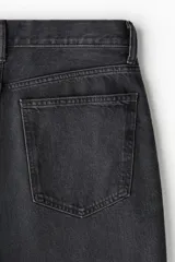 Pantalón de jean negro de corte holgado, con tiro bajo y cinco bolsillos.