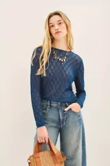 Remera negra de tejido calado con lurex, corte ajustado y mangas largas.