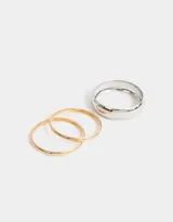 Set de tres pulseras rígidas doradas de metal, de diferentes tamaños.