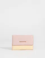 Billetera rectangular de cuerina color rosa y amarillo, con solapa con broche para cerrado y tag metálico con la frase "Charmed by you".