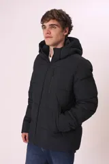 Campera puffer gris con capucha, cierre frontal con cremallera y bolsillos laterales con cierre.