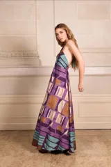 Vestido largo con estampado geométrico en tonos violeta, marrón y celeste, con cuello halter y espalda descubierta.