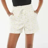 Short de tiro alto color blanco con estampado de limones amarillos, cintura elastizada con cordón ajustable y bolsillos laterales.