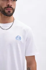 Remera blanca de algodón de manga corta con cuello redondo y bordado de un croissant azul en el pecho.