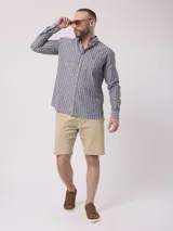 Camisa de manga larga a rayas verticales azules y blancas, con cuello abotonado y bolsillo en el pecho. Confeccionada en lino y algodón.