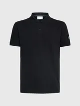 Chomba negra de piqué de algodón peinado, corte regular, cuello clásico con dos botones, mangas cortas, dobladillo con aberturas laterales y logo de Calvin Klein en la manga.