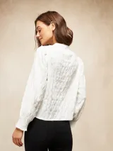 Camisa blanca de manga larga con textura arrugada, cuello mao y puños elásticos.