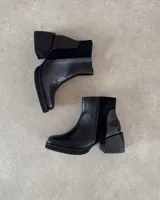 Botines negros de cuero vacuno, con paneles de cuero liso y gamuza.