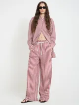 Camisa a rayas rojas y blancas, con cuello camisero, botones en la parte delantera y largo mayor en la espalda.