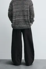Pantalón de jean negro de corte amplio, estilo balloon fit, con cinco bolsillos y cierre frontal con botones.