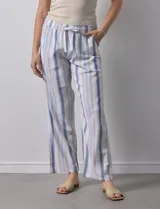 Pantalón de lino estampado a rayas verticales azules y blancas, marca DASH. Tiene pretina ancha elastizada con lazo ajustable.