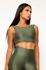 Top deportivo color ladrillo, de poliamida con acabado brillante y textura acanalada, con cuello redondo y espalda escotada.