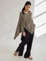 Chal color beige con diseño jacquard, de forma rectangular y caída fluida.