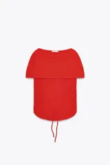 Top rojo de tejido texturizado, con escote multiposición y tiras ajustables.