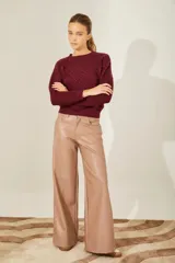 Sweater color borgoña de punto con cuello redondo, diseño de rombos con tachas aplicadas y detalle de corazones de cuero en la espalda.