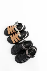 Sandalias negras de cuero con tiras horizontales y hebilla plateada.