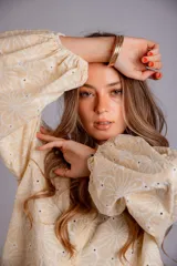 Camisa celeste con estampado de flores blancas, corte clásico, cuello camisero y mangas largas abullonadas.