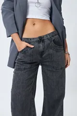 Pantalón de jean gris oscuro, tiro bajo, corte baggy y doble bolsillo.