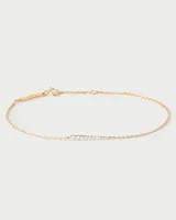 Pulsera dorada con cadena fina y pequeños cristales blancos.