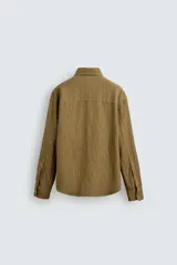 Sobrecamisa color caqui de algodón y lino con efecto arrugado, corte relaxed fit, cuello solapa, manga larga con puños abotonados y cierre frontal con botones.