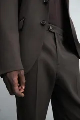 Pantalón de vestir negro de lana, corte recto, con bolsillos laterales y traseros de ojal con botón.