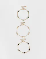 Set de tres pulseras doradas con dijes de flores de metal y resina.