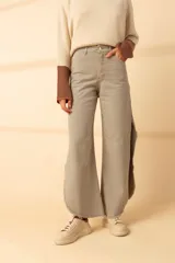 Pantalón de jean color gris claro, de corte recto y tiro alto, con tajos laterales y terminación desflecada.