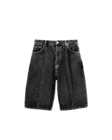 Bermuda de jean negro con efecto lavado, corte amplio, costuras expuestas y bolsillos traseros grandes.