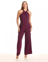 Enterito largo de crepe color rojo, con escote halter anudado y pierna ancha. Presenta bolsillos delanteros y abertura en la espalda con cierre invisible y botón.