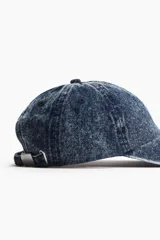 Gorra de jean azul con visera curva y hebilla metálica ajustable en la parte trasera.