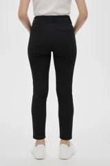 Pantalón largo color beige, de corte skinny, con bolsillos delanteros y traseros.