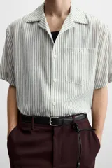 Camisa de hombre relaxed fit con cuello bowling y manga corta, confeccionada en tejido fluido con mezcla de viscosa a rayas verticales en tonos verde y blanco.