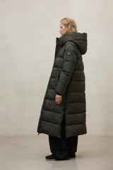 Chaqueta larga acolchada color verde militar, con capucha y cierre frontal. Confeccionada con poliéster 100% reciclado, forro y relleno PrimaLoft 100% reciclados.