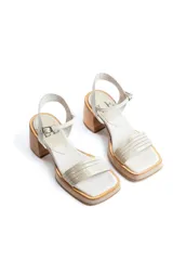 Sandalias de tacón color beige con puntera cuadrada, tiras doradas en el empeine y tobillo, y taco cuadrado.