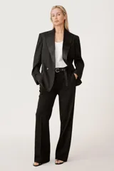 Blazer negra cruzada con cuello solapa de muescas en tejido combinado a tono, bolsillos con solapa en delantero y de vivo en pecho, bajo acabado con abertura en espalda.