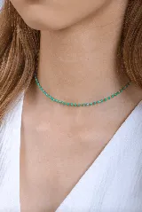 Gargantilla dorada con pequeñas cuentas facetadas de color verde esmeralda.