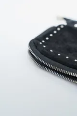 Cartera de mano o clutch color rojo oscuro (bordó) con textura de gamuza o terciopelo. Presenta tachas metálicas plateadas a lo largo del borde inferior y lateral, y un cierre perimetral plateado. Incluye una correa de hombro desmontable compuesta por una tira de material a tono y cadena metálica plateada.