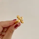 Anillo dorado de acero quirúrgico hipoalergénico con baño en oro 18K, con diseño de flor.