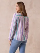 Blusa de lino estampada a rayas verticales de colores blanco, verde, lila, amarillo y rosa. Tiene cuello a la base con escote en V y abertura central con botones. Cuenta con dos bolsillos frontales y mangas largas regulables con presilla y botón. Marca Zac & Rachel.