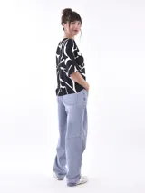 Remera de manga corta con cuello redondo, color negro con estampado abstracto en blanco.