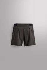Shorts deportivos marrones de tejido técnico ligero y elástico con diferentes estructuras. Tiene forro interior, cintura elástica ajustable con cordón, bolsillos frontales, bolsillo trasero con cierre, aberturas laterales y logo estampado en la pierna.