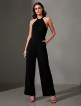 Enterito largo de crepe color rojo, con escote halter anudado y pierna ancha. Presenta bolsillos delanteros y abertura en la espalda con cierre invisible y botón.