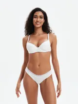 Conjunto de ropa interior femenina color blanco, compuesto por un corpiño con aro y puntilla en el escote, y una bombacha tipo bikini con puntilla en la cintura.