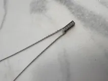 Collar de cadena fina plateada con dije de la letra "F" incrustada con strass.